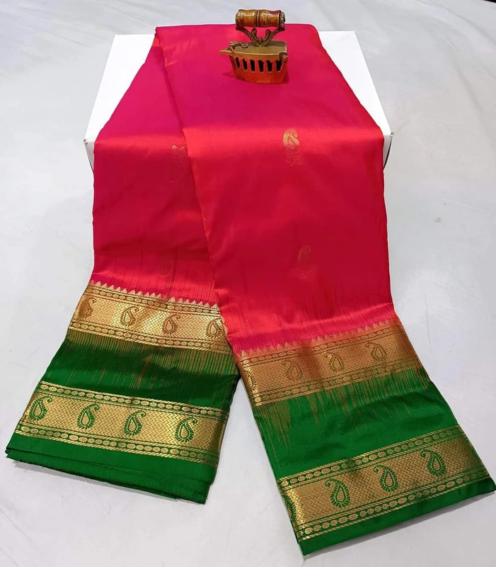 Hot pink silk saree with green and gold Bentex border with paisley designs.