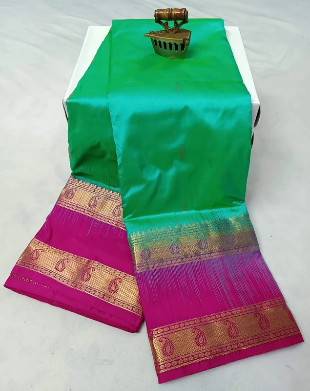 Green Kanchipuram silk saree with pink and gold Bentex border and paisley motifs.