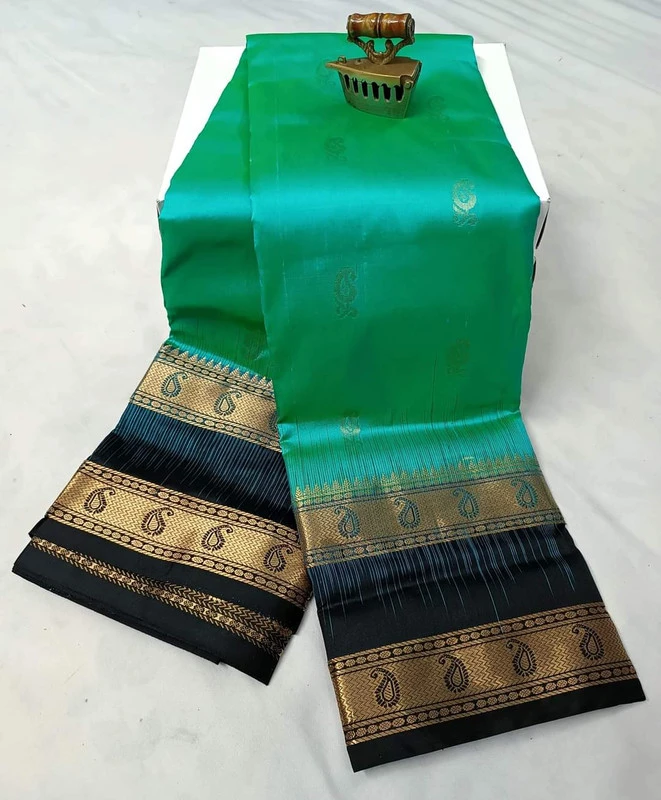 Emerald green silk saree with black and gold Bentex border and paisley motifs.
